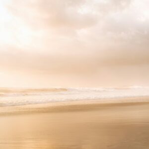 femme marchant seule au bord de l'océan symbolisant l'hypervigilance et l'anxiété chez les personnes sensibles – retrouver l’apaisement et la sécurité intérieure