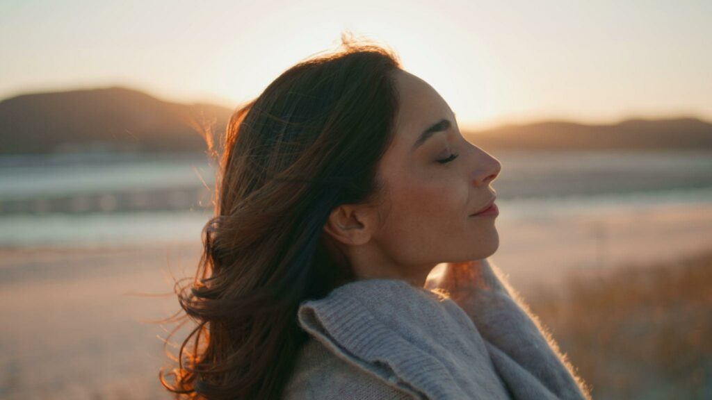 Femme dans la nature au coucher du soleil illustrant la périménopause comme passage de vie et transformation intérieure